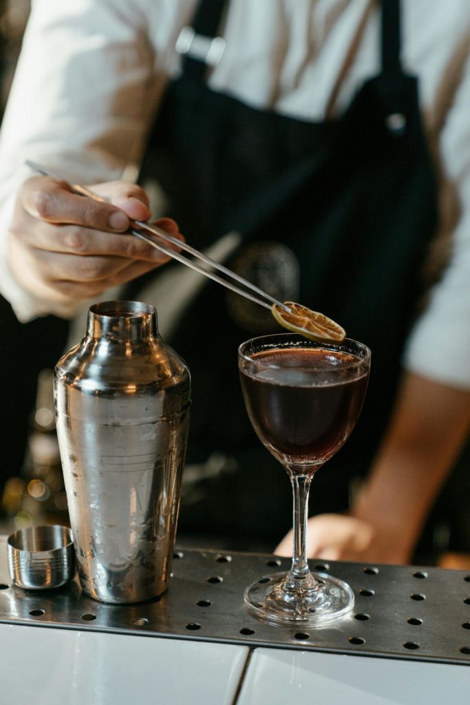 Bartender putting a fruit garnish on a cocktail